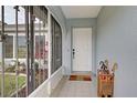 Front entry with white door, screened porch, and tiled floor at 2798 Rock Creek Dr, Port Charlotte, FL 33948