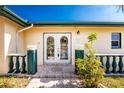 House exterior featuring double arched entry doors and lush landscaping at 3200 Colony Ct, Punta Gorda, FL 33950