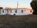 Side view of a single story home with white exterior and a grassy yard at 3740 Easy St, Port Charlotte, FL 33952