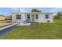 Cute bungalow with a white exterior, landscaped yard, and a walkway at 3740 Easy St, Port Charlotte, FL 33952