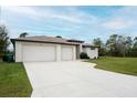 Two-car garage and driveway, manicured lawn at 5435 Montego Ln, Port Charlotte, FL 33981