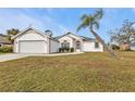 Front yard view of a single-story house with a palm tree at 87 Torrington St, Port Charlotte, FL 33954