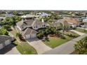 An aerial view showcasing a two-story house with a two car garage and lush landscaping at 9458 Snapper Cir, Port Charlotte, FL 33981