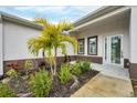 Front entrance with palm tree and well-maintained landscaping at 99 Sundiet St, Port Charlotte, FL 33954