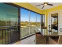 This screened patio features a fan, a glass table, and a view of Florida's beautiful landscape at 10501 Amberjack Way # 101, Englewood, FL 34224