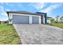 Modern home with gray paver driveway and two-car garage at 15133 Amsterdam, Port Charlotte, FL 33981
