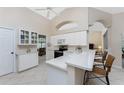 Bright kitchen with white cabinets, breakfast bar, and tile flooring at 188 Broadmoor Ln, Rotonda West, FL 33947