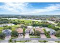 Aerial view of homes with tile roofs in a lakeside community with golf course at 25187 Keygrass Ct, Punta Gorda, FL 33955