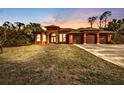 Stunning house exterior at sunset, three-car garage, and manicured lawn at 3000 Narcissus Ter, North Port, FL 34286