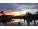 Stunning sunset over calm water with lush landscape and dock at 3513 Terin Ct, Punta Gorda, FL 33950