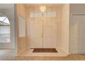 Bright entryway with double doors, chandelier, and tile flooring at 4046 Lubec Ave, North Port, FL 34287