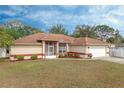 Tan house with brown roof, white garage door, and landscaped yard at 4046 Lubec Ave, North Port, FL 34287