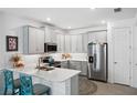 L-shaped kitchen with white cabinets, stainless steel appliances, and a large island at 43620 Sparrow Dr, Punta Gorda, FL 33982