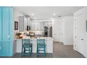 Modern kitchen with white cabinets, stainless steel appliances, and teal accents at 43620 Sparrow Dr, Punta Gorda, FL 33982