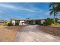 Single-story home with a carport and palm trees at 450 Capri Isles Ct, Punta Gorda, FL 33950