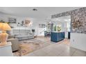Open concept living room and kitchen with a gray couch, blue island, and coastal decor at 745 Kellstadt Nw St, Port Charlotte, FL 33952