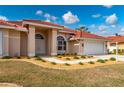 Front view of a single-story house with tile roof and landscaping at 8326 Creekview Ln, Englewood, FL 34224