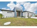 Modern home with a two-car garage and spacious front yard at 9516 President Cir, Port Charlotte, FL 33981