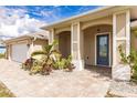 Front entrance with a blue door and landscaped walkway at 13039 Ridgely Cir, Port Charlotte, FL 33981