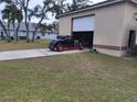 Detached garage with classic car and lawn mower at 14057 Maxwell Ave, Port Charlotte, FL 33953