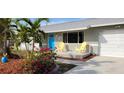 Brightly colored home exterior, featuring a manicured lawn, and a welcoming front porch at 18086 Clanton Ave, Port Charlotte, FL 33948