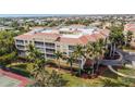 Aerial view showcasing the building's location, landscaping, and nearby tennis court at 255 W End Dr # 3301, Punta Gorda, FL 33950