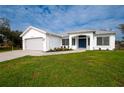 White house with gray roof and a blue front door at 29350 Goodhue St, Punta Gorda, FL 33982