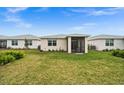 Rear view of a single story home with screened porch and grassy lawn at 44259 Saddlewood Ct, Punta Gorda, FL 33982