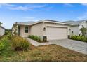 One-story home with attached garage, landscaping, and a paved driveway at 44259 Saddlewood Ct, Punta Gorda, FL 33982