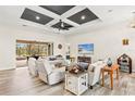 Open living room featuring a coffered ceiling and access to the backyard at 500 Woodstork Ln, Punta Gorda, FL 33982