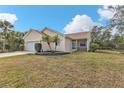 Tan house with a two-car garage, palm trees, and a grassy yard at 5547 Wagon Wheel Dr, North Port, FL 34291