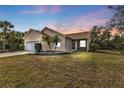 House exterior at dusk, featuring a two-car garage and landscaping at 5547 Wagon Wheel Dr, North Port, FL 34291