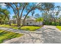 House exterior showcasing a metal roof, landscaping, and a long driveway at 7563 Albert Tillinghast Dr, Sarasota, FL 34240