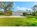 Three-car garage with metal roof and landscaping at 7563 Albert Tillinghast Dr, Sarasota, FL 34240