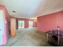 Spacious living room with light pink walls, carpeting, and a chandelier at 7570 Berwick St, North Port, FL 34287