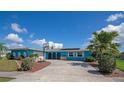 Nice curb appeal, featuring a bright blue house, driveway, and basketball hoop at 125 Severin Se Rd, Port Charlotte, FL 33952