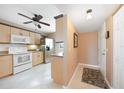 Bright kitchen with wood cabinets, white appliances, and breakfast bar at 175 Kings Hwy # 528, Punta Gorda, FL 33983