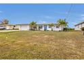 Single story home with a large front yard and palm trees at 226 Spring Lake Nw Blvd, Port Charlotte, FL 33952