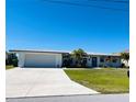 White single story home with a metal roof, attached garage, and a spacious driveway at 226 Spring Lake Nw Blvd, Port Charlotte, FL 33952