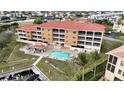 Aerial view showing condo building, pool, and surrounding landscape at 3322 Purple Martin Dr # 126, Punta Gorda, FL 33950