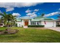 White house with green metal roof and landscaped yard at 3412 Nighthawk Ct, Punta Gorda, FL 33950