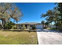 Ranch-style home with a two-car garage and lush landscaping at 514 Orlando Blvd, Port Charlotte, FL 33954