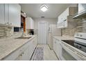 White kitchen with granite countertops and modern appliances at 103 Atwater St, Port Charlotte, FL 33954