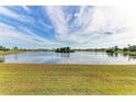 Serene lakefront view with lush green grass at 1115 Venture Ct, Punta Gorda, FL 33983