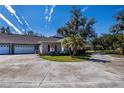 Tan house with red shutters and a two-car garage, surrounded by lush landscaping at 1447 Red Oak Ln, Port Charlotte, FL 33948