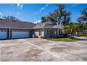 Two car garage with a large concrete driveway and mature trees at 1447 Red Oak Ln, Port Charlotte, FL 33948