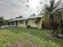 Bright yellow house with teal accents and a large grassy yard at 2115 Myrtle Ave, Punta Gorda, FL 33950