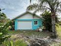 Detached garage with a white door and light teal exterior at 2115 Myrtle Ave, Punta Gorda, FL 33950