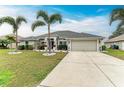 House exterior showcasing landscaping, a driveway, and a two-car garage at 2467 Odessa Ln, Punta Gorda, FL 33983