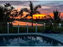 Stunning sunset view from a backyard pool with a cable railing and landscape at 3845 Bal Harbor Blvd, Punta Gorda, FL 33950